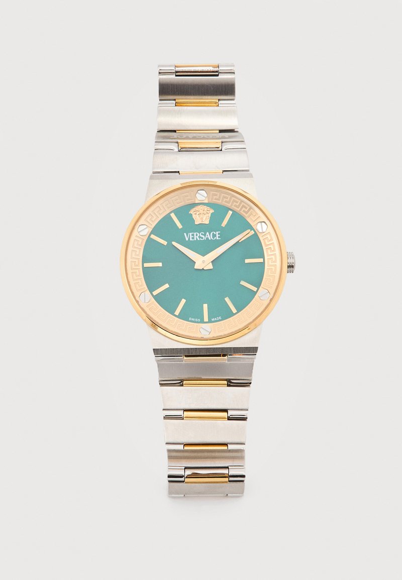 Strieborné a zlaté kovové hodinky na zápästie s tyrkysovým ciferníkom, zlatými hodinovými značkami, logom Versace a detailom hlavy Medúzy na lunete.