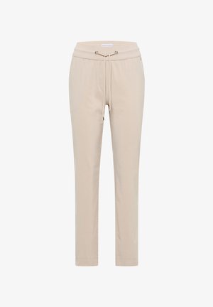 Pantalon beige fuselé avec taille élastique et cordon de serrage, doté d'œillets en métal et d'ourlets cousus.