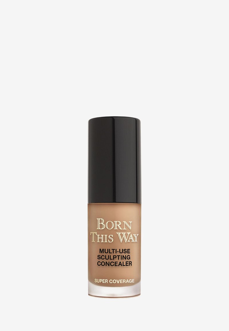 Born This Way Multi-Use Sculpting Concealer in een doorzichtig glazen fles met een zwarte dop. Lichte bruine vloeistof zichtbaar. Super Coverage-label.