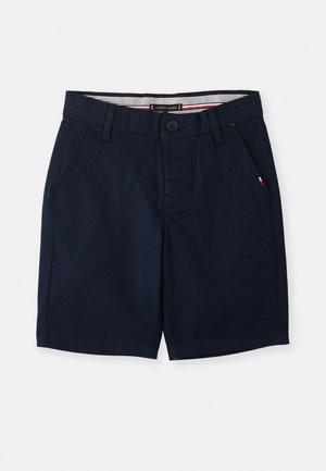 Shorts en coton bleu marine avec une coupe droite, des poches avant et une fermeture à boutons. Présente une ceinture intérieure rayée et un petit accent de logo.