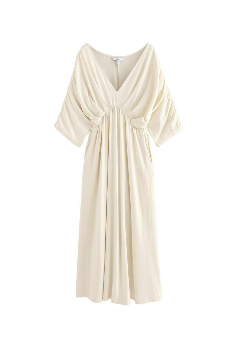 Vestido color crema con escote en V, mangas cortas de gran tamaño, cintura fruncida y tejido fluido, diseñado para una silueta de ajuste holgado.
