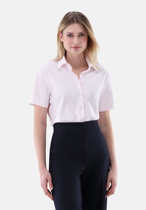 Hellrosa kurzärmeliges Hemd mit Kragen, vorne mit Knöpfen und dezenten vertikalen Streifen, kombiniert mit hochtaillierter schwarzer Hose.