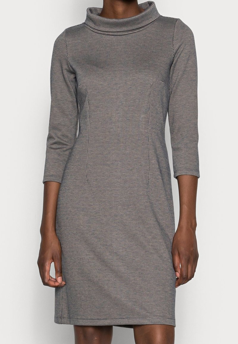Šaty s kapucí vyrobené z texturované šedé látky s kostkovaným vzorem, úzký střih, tříčtvrteční rukávy a rovný lem.