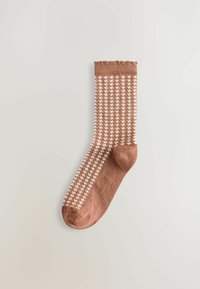 Bruine sok met een wit houndstooth-patroon, met een geribbelde boord aan de bovenkant, gepresenteerd tegen een lichte achtergrond.