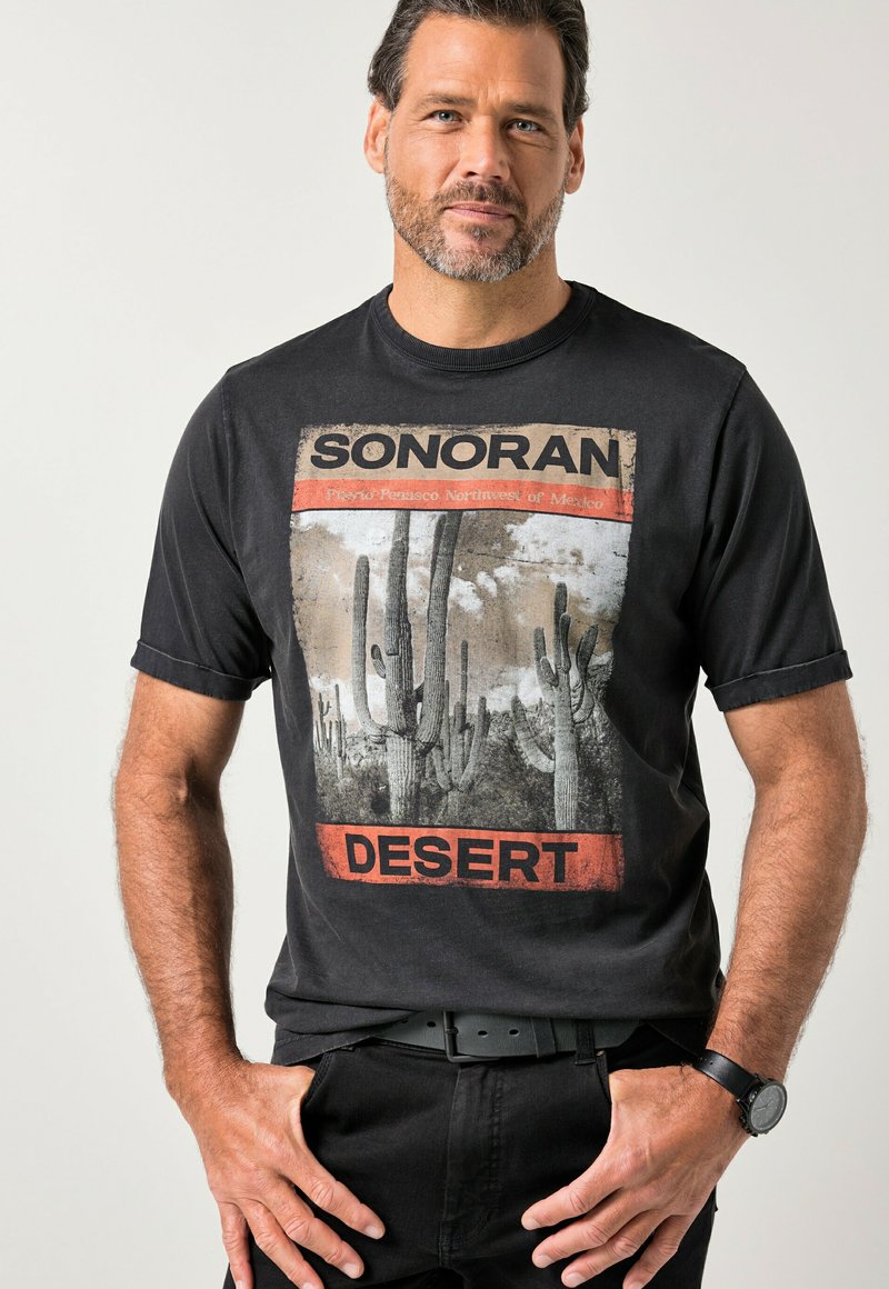 Czarna bawełniana koszulka z krótkim rękawem, na której znajduje się graficzny nadruk pustynnych kaktusów oraz napis „SONORAN DESERT” w kolorach czerwonym i beżowym.