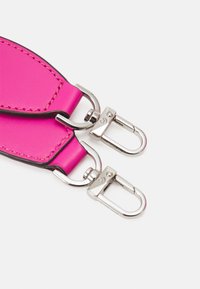 Cinturino in pelle rosa con cuciture nere, dotato di clip metalliche argentate per il fissaggio. Texture liscia, forma rettangolare con angoli arrotondati.