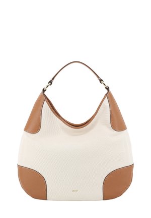 Beige Canvas-Hobo-Tasche mit braunen Lederakzenten, abgerundeter Form, einem einzelnen Träger und dezentem Logo in der Nähe der Basis.