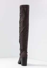 Botas por encima de la rodilla en ante gris oscuro con detalle de cordones en el lateral exterior y un tacón grueso texturizado. Acabado de superficie suave.