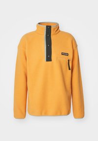 Orange fleecetröja med halvdragkedja och krage, grå accenter, svarta tryckknappar och en dragkedjeförsedd bröstficka med en logotyp.