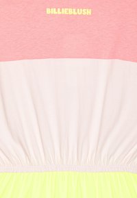 Kolorowa sukienka z różową górną częścią, białym środkiem i jasnym żółtym dołem. Posiada marszczoną talia oraz nazwę marki "BILLIEBLUSH" w kolorze żółtym.