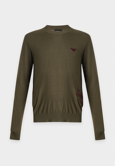 Pull vert olive à manches longues avec col rond, poignets et bas côtelés, avec un petit logo rouge foncé sur la poitrine et sur le côté.
