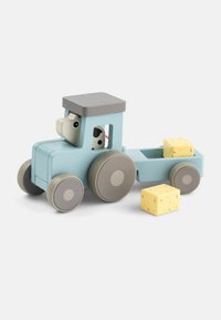 Drevený hračkársky traktor v svetlomodrej farbe s šedými akcentmi, s usmievavým vodičom zvieraťa, sprevádzaný dvoma žltými blokovými nákladnými kusmi.
