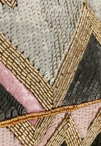 Bolso de mano con cuentas que presenta lentejuelas en gris, negro, beige y rosa. Detalles metálicos y bordados intrincados detallan el diseño geométrico.