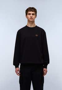 Black sweatshirt with a round neckline and ribbed cuffs, featuring a small circular logo on the chest. Simple, casual design.