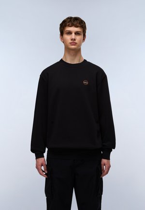 Black sweatshirt with a round neckline and ribbed cuffs, featuring a small circular logo on the chest. Simple, casual design.