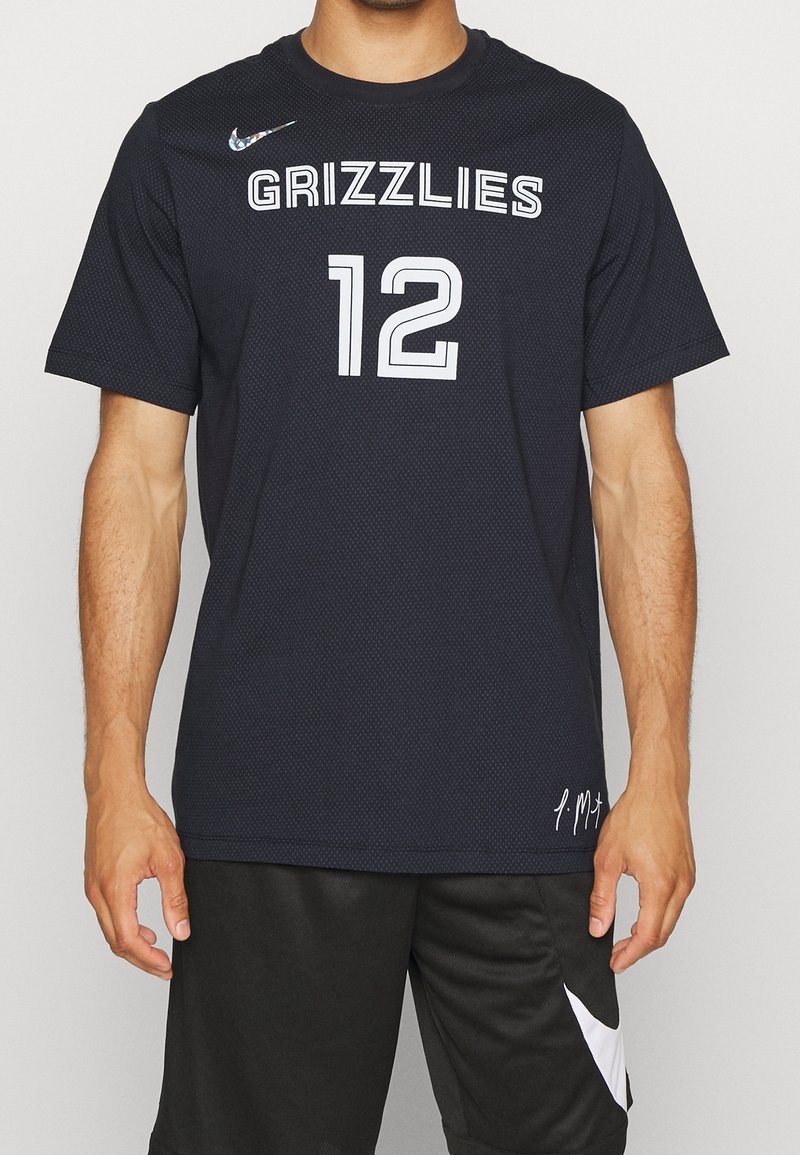 Černý krátký rukáv Nike dres, síťovaná textura, s nápisem "GRIZZLIES" a číslem "12" v bílé barvě. Obsahuje signaturu na spodním okraji.
