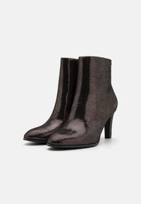 Bottines avec une finition métallique brun foncé brillante, surface texturée, pointe fine et un talon haut élancé.