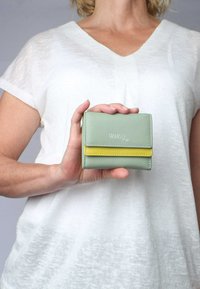 Green and yellow leather wallet, rectangular shape, featuring a front flap, visible stitching, and the brand name "VARGU" embossed on the front.