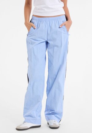 Light blue athletic pants with an elastic waistband, side pockets, black side stripes, and a relaxed fit. Made from textured fabric.