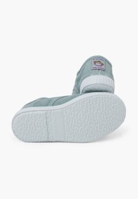 Světle zelené plátěné boty s texturovanou bílou gumovou podrážkou, sešité logem na patě a elastickými bočními panely.