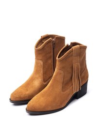 Stivaletti in camoscio color cuoio con punta appuntita, cerniera laterale e dettaglio con nappina sul retro. Il tacco a blocco offre stabilità e altezza.