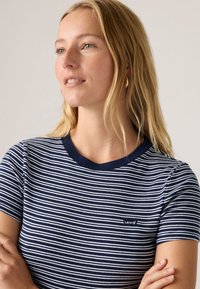 Navyblauw-wit gestreept T-shirt met korte mouwen, een ronde hals en een klein Levi's-logo op de linkerborst. Zacht katoenen materiaal.