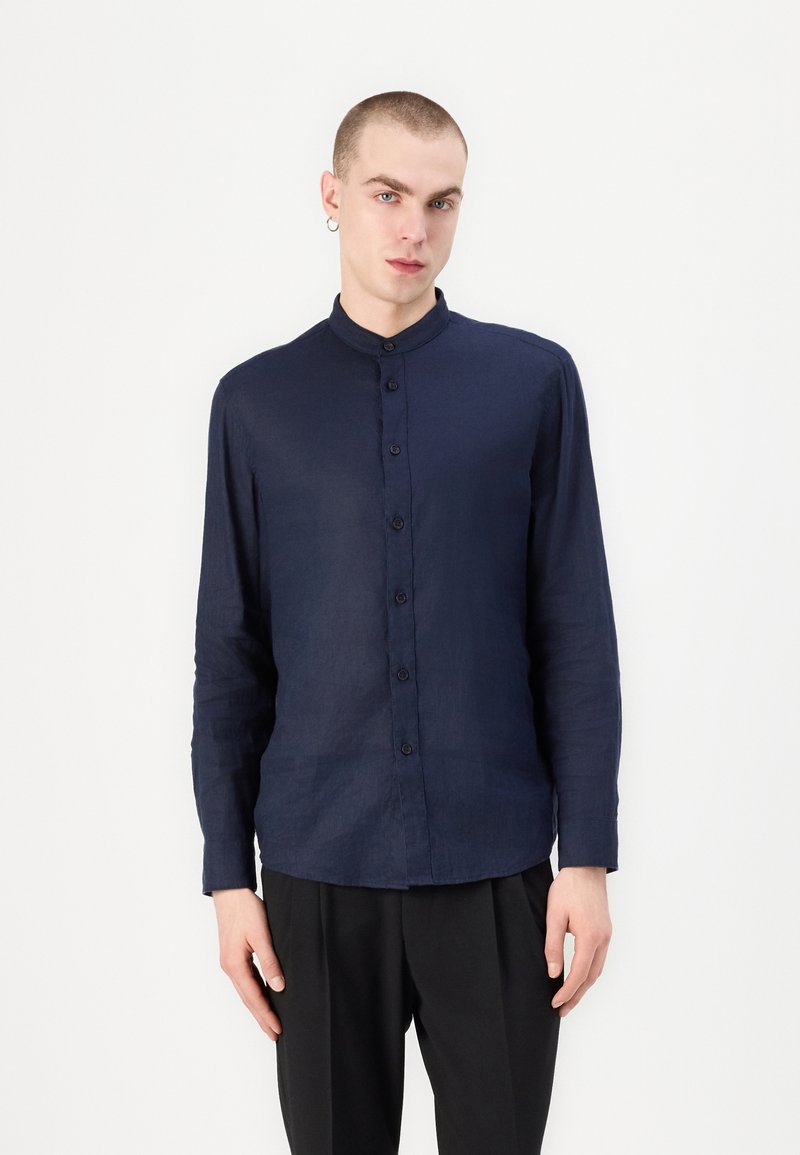 Camicia a maniche lunghe di colore blu navy, realizzata in lino leggero, con colletto alla coreana e chiusura frontale a bottoni, dal design slim fit.