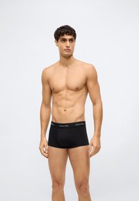 Černé bavlněné boxerky mají měkký pas s logem "Calvin Klein". Přiléhavý design zvyšuje tvar a pohodlí.