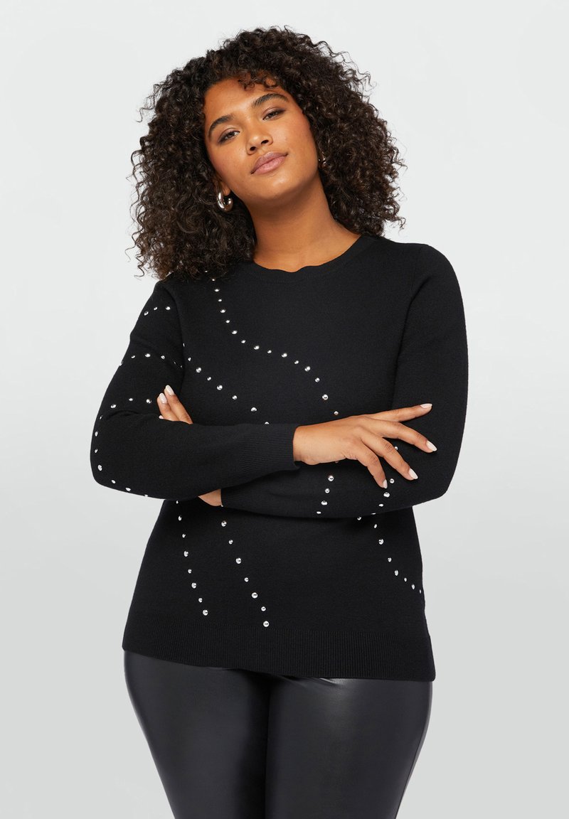 Maglione nero a maniche lunghe con scollatura rotonda, decorato con borchie argentate disposte in un motivo a spirale sul davanti. Tessuto testurizzato.