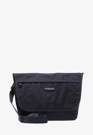Sac messager noir Tommy Hilfiger avec bandoulière réglable et fermeture à rabat avant.