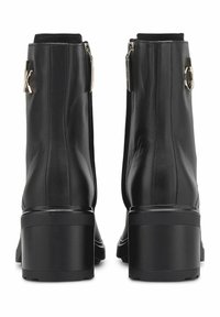 Botas de cuero negro hasta el tobillo con tacón cuadrado redondeado, cremalleras traseras y detalles de logo en los laterales. Textura suave con un diseño elegante.