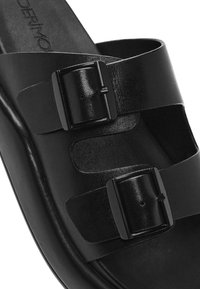 Czarna skórzana klapka ze dwoma regulowanymi paskami z czarnymi prostokątnymi klamrami na czarnej podeszwie.