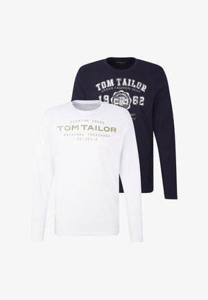 Dva trička s dlouhým rukávem: jedno bílé se zeleným textem, druhé tmavě modré s bílými motivy. Obě mají kulatý výstřih a měkkou látku.