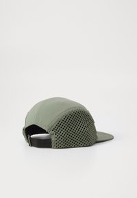Green cap with a solid front and mesh back, featuring a curved brim, adjustable strap, and stitched detailing along the edges.