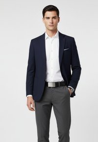 Navy blazer, white dress shirt, gray patterned trousers, black belt with silver buckle, and a wristwatch. Tailored fit and structured design.
