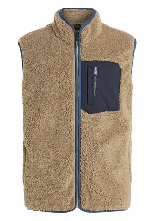 Tan fleece vest with high collar, front zipper, and navy pocket. Features plush texture and blue trim along the edges for contrast.