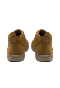 Botines de ante marrón con una textura suave, collar redondeado y un pequeño tacón. Cuenta con una lengüeta y suela de goma para mayor agarre.