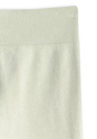 Tissu tricoté côtelé vert clair en gros plan, mettant en avant la ceinture élastique et les détails de la texture verticale.