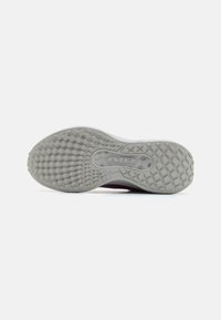 Nike sportcipő talpa világosszürke gumiból készült, texturált mintázattal, különböző formákkal és barázdákkal a tapadás érdekében.