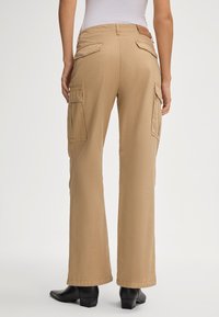 Beige cargobroek van katoen, met twee achterzakken en zijcargozakken. Relaxte pasvorm met een rechte pijp.