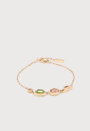 Goldkette-Armband mit grünen und rosa Edelsteinen sowie einem kleinen Krokodil-Anhänger auf weißem Hintergrund.