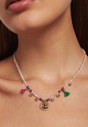 Collier coloré comprenant un mélange de perles rondes de différentes couleurs, des accents dorés et des franges décoratives. Pendentif central remarquable avec des gemmes.