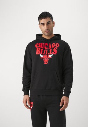 Sort hætte trøje med "Chicago Bulls" logo i rød, med en kængurulomme og ribbede manchetter. Matchet med sorte bukser og et lignende logo.