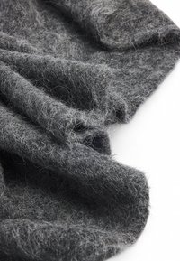 Grå uldstof med en blød, fnugget tekstur, der har et let krøllet udseende og fine fibre spredt over det.