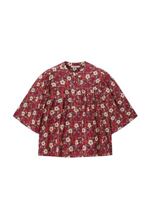 Blouse rouge à fleurs blanches et roses, col rond, manches trois-quarts et tissu froncé sous le yoke.