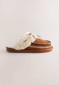 Chausson marron à enfiler avec doublure en fausse fourrure blanche, surpiqûres décoratives et semelle plate sur fond uni.