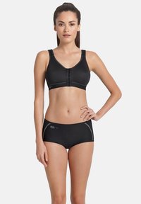 Schwarzer Sport-BH mit Frontverschluss und breiten Trägern, kombiniert mit schwarzen Hipster-Shorts, die eine glatte Textur und reflektierende Akzente aufweisen.