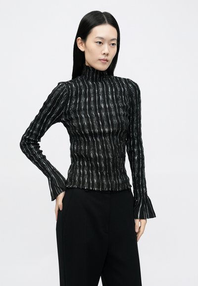 Top negru cu mâneci lungi și guler înalt, având dungi verticale argintii și manșete evazate. Textură netedă cu o siluetă mulată.