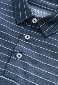 Polo bleu marine à manches courtes avec des rayures horizontales blanches, une patte de boutonnage avec des boutons circulaires et un col rabattable.