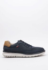 Zapato de cuero azul marino con tacón de ante marrón, diseño de cordones, suela blanca y detalles cosidos. Presenta un pequeño logo de marca rojo en el lado.